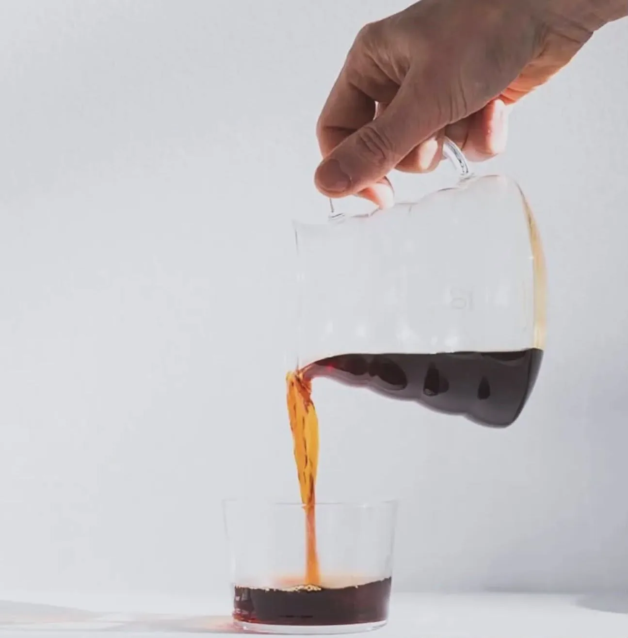 Filterkaffee wird aus der Karaffe ins Glas gegossen