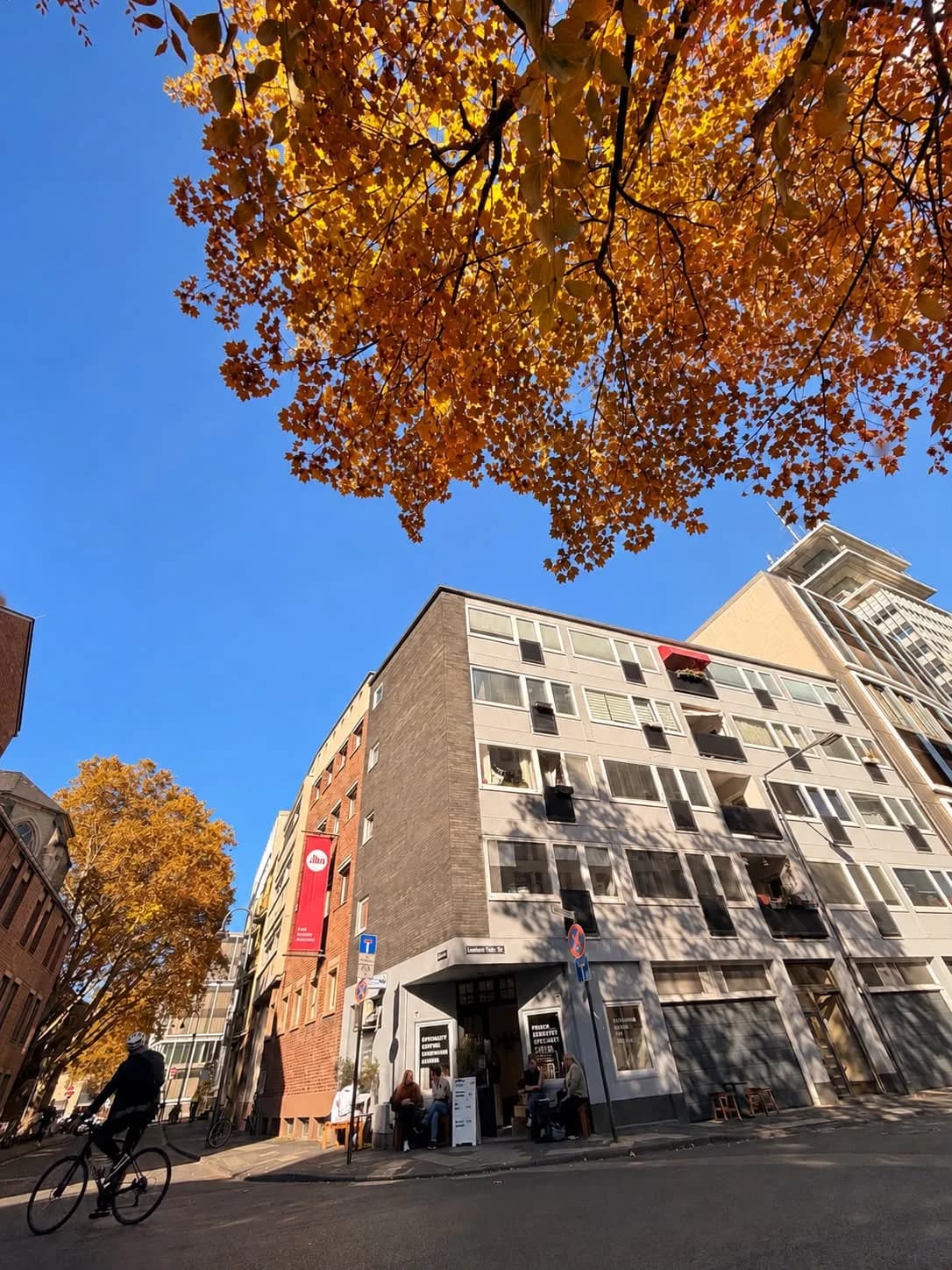 Herbstliche Straße in Köln mit dem Café im Hintergrund