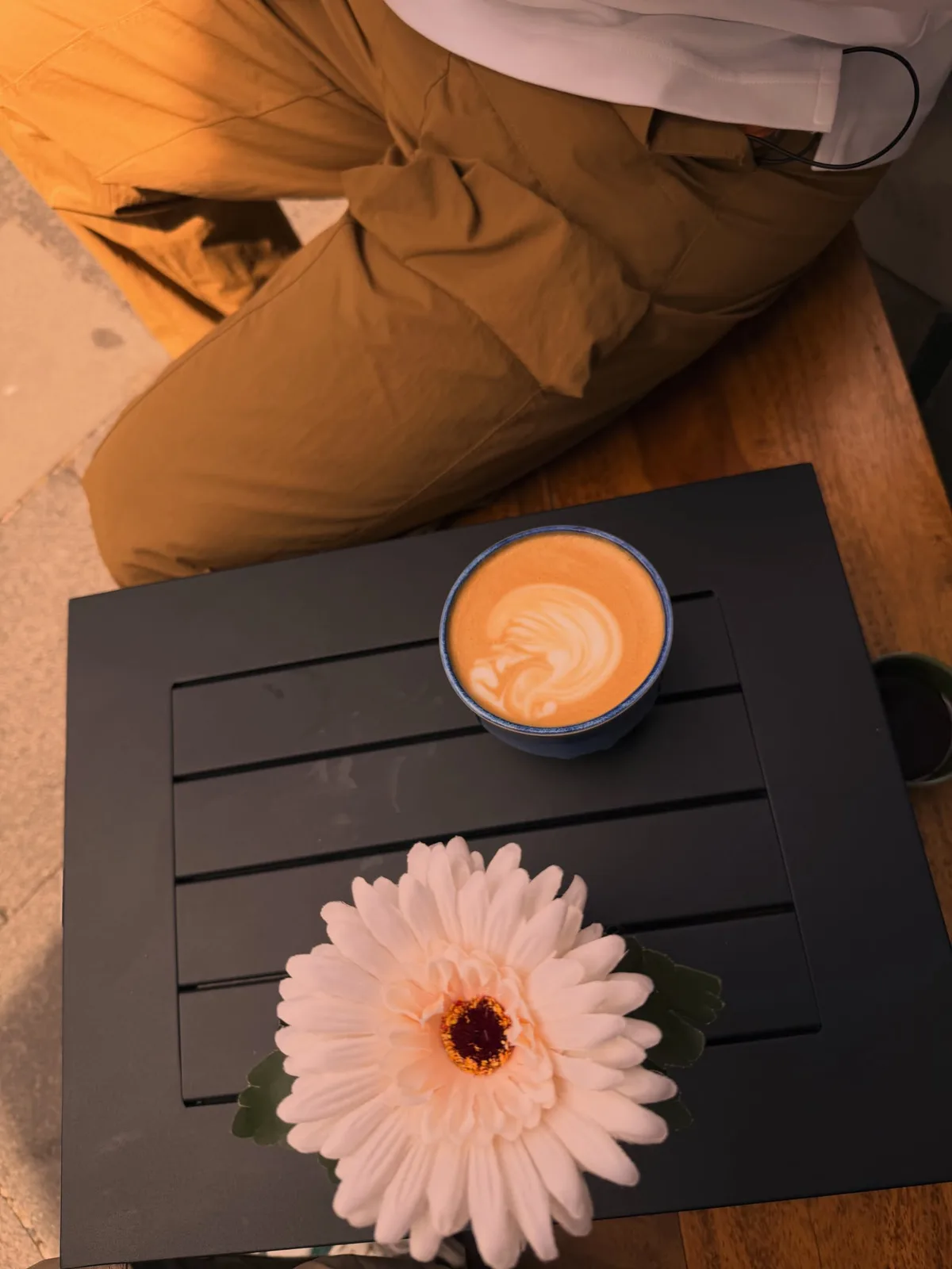 Latte Art und Blume auf dem Tisch